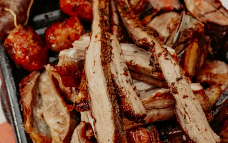 Argentine asado tray with grilled beef ribs and chorizo criollo from La Charito's live Latino BBQ catering
